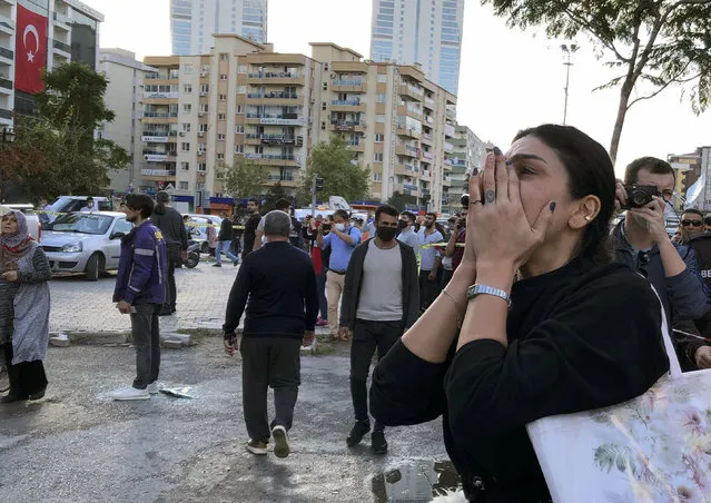 A woman watches as rescue workers try to save people trapped in the debris of a collapsed building, in Izmir, Turkey, Friday, October 30, 2020. (Photo by Ismail Gokmen/AP Photo)