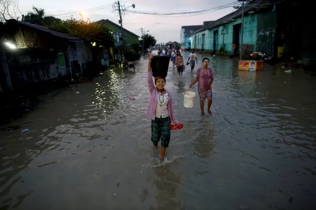 A girl carries a basket on her head as she walks along a flooded street in Yangon in this September 30, 2015 file photo. (Photo by Soe Zeya Tun/Reuters)