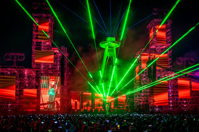 Spectators cheer as electronic music pioneer Jean-Michel Jarre performs during the opening concert of the Starmus festival in Bratislava, Slovakia, on May 12, 2024. Starmus is a global festival of science communication and the arts. The spectacular concert show, in which Jarre also performed with Queen guitarist and astrophysicist Brian May and which took place against the backdrop of the iconic UFO-shaped bridge over the Danube River in the Slovak capital, was full of light and pyrotechnic effects and was free to the general public. (Photo by Tomas Benedikovic/AFP Photo)