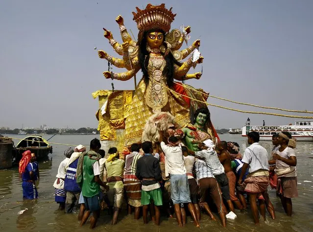 Devotees immerse an idol of the Hindu goddess Durga into the Ganges river after the end of the Durga Puja festival in Kolkata, India, October 25, 2015. The Durga Puja festival is the biggest religious event for Bengali Hindus. Hindus believe that the goddess Durga symbolises power and the triumph of good over evil. (Photo by Rupak De Chowdhuri/Reuters)