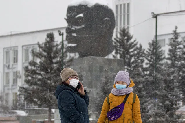 Two women wearing face masks to protect against coronavirus stand in front of a monument of Vladimir Lenin in Ulan-Ude, the regional capital of Buryatia, a region near the Russia-Mongolia border, Russia, Friday, November 20, 2020. Russia’s health care system has been under severe strain in recent weeks, as a resurgence of the coronavirus pandemic has swept the country. (Photo by Anna Ogorodnik/AP Photo)
