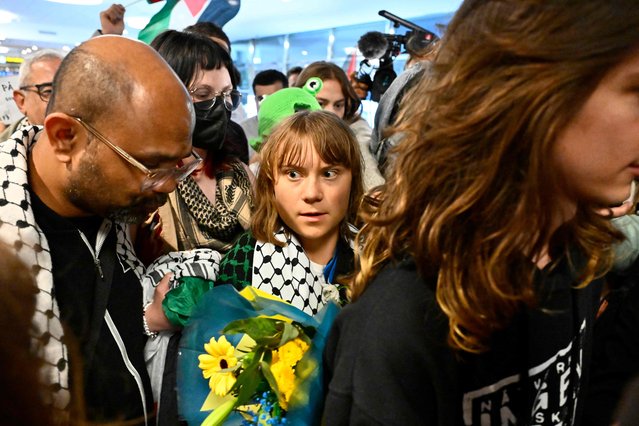 Swedish campaigner Greta Thunberg (C) looks on as she is greeted on arrival at Stockholm-Arlanda airport, on the outskirts of Stockholm, on June 10, 2025. On June 10, 2025, Israel deported Swedish Greta Thunberg by plane to Sweden via France, after she was arrested on board an aid boat for Gaza with other pro-Palestinian activists who were taken to Ben Gurion airport for deportation. Of the 12 people on board the sailing boat Madleen, two French nationals agreed to be deported on June 10, while four others declined pending a court decision, French Foreign Minister Jean-Noël Barrot announced. (Photo by Anders Wiklund/TT News Agency via AFP Photo)