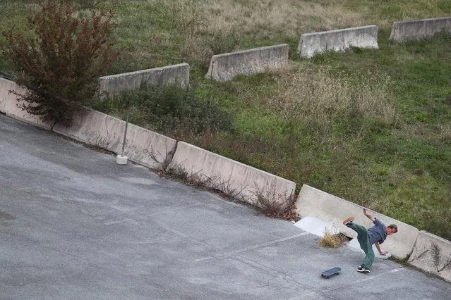 A skateboarder falls down while attempting to land a trick along a vacant parking lot in the Riverfront neighborhood of Wilmington, Delaware U.S. November 21, 2020. (Photo by Tom Brenner/Reuters)