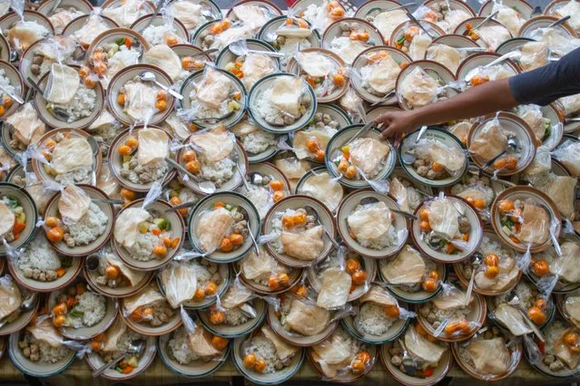 A Muslim person prepares meals for breaking fast during the Islamic holy month of Ramadan at a mosque in Yogyakarta on March 28, 2023. (Photo by Devi Rahman/AFP Photo)