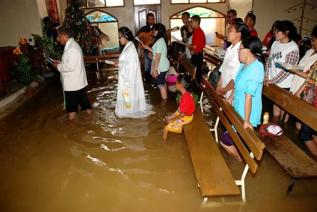 Christians attend the mass service at a flooded church in Bandung, in western Java island, on December 25, 2014. Millions of Christians in Indonesia celebrate the Christmas eve in the most populous Muslim country. (Photo by Timur Matahari/AFP Photo)