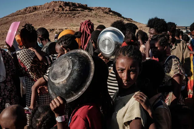 Ethiopian refugee children who fled the Ethiopia's Tigray conflict wait in a line for a food distribution by Muslim Aid at the Um Raquba refugee camp in Sudan's eastern Gedaref state on December 12, 2020. (Photo by Yasuyoshi Chiba/AFP Photo)