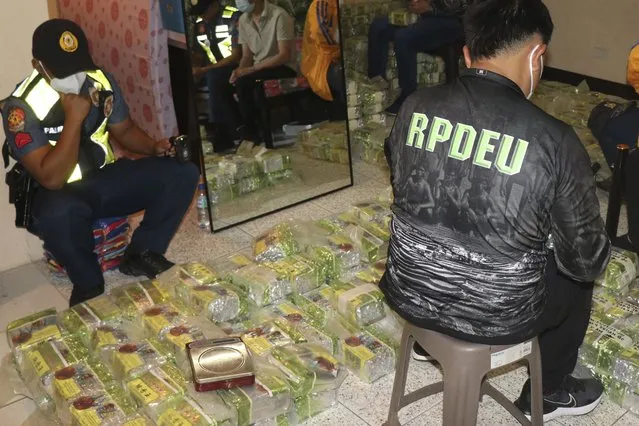 In this photo provided by the Police Regional Office Cordillera RPIO, policemen inspect tea bags containing suspected methamphetamine during a raid at a house in Baguio city, northern Philippines on Wednesday March 29, 2023. Philippine police seized more than 500 kilograms (more than half a ton) of suspected methamphetamine concealed in tea bags Wednesday and arrested a suspected Chinese drug dealer in a northern mountain resort city, police officials said. (Phoot by Police Regional Office Cordillera RPIO via AP Photo)