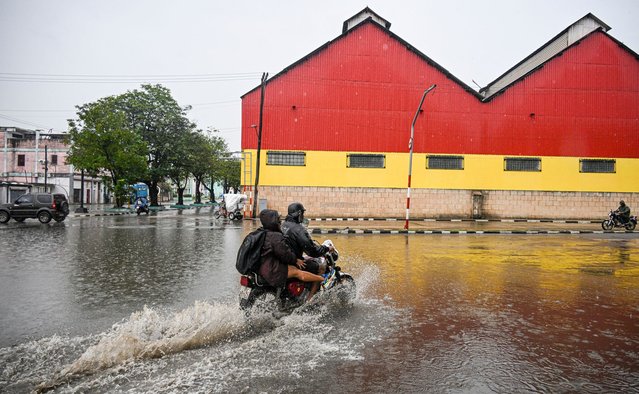 Residents ride motorcycles through flooded areas before Hurricane Melissa hits the city of Santiago de Cuba, Cuba on October 28, 2025. Hurricane Melissa was set to strike nearby eastern end of Cuba late Tuesday after pummeling Jamaica. (Photo by Yamil Lage/AFP Photo)