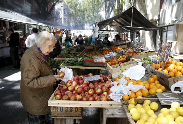 A woman buys fruits in a street market in downtown Montevideo, Uruguay November 6, 2015. (Photo by Andres Stapff/Reuters)