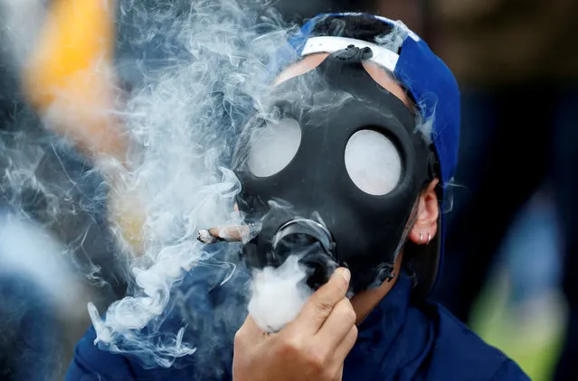 A man smoking marijuana through a mask during a Global March for marijuana in Bogota, Colombia, May 5, 2018. (Photo by Jaime Saldarriaga/Reuters)