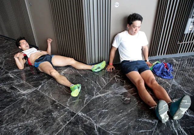 Participants rest after finishing a vertical marathon, which was held in the 123-floor Lotte World Tower in Seoul, South Korea May 13, 2018. (Photo by Kwak Sung-Kyung/Reuters)