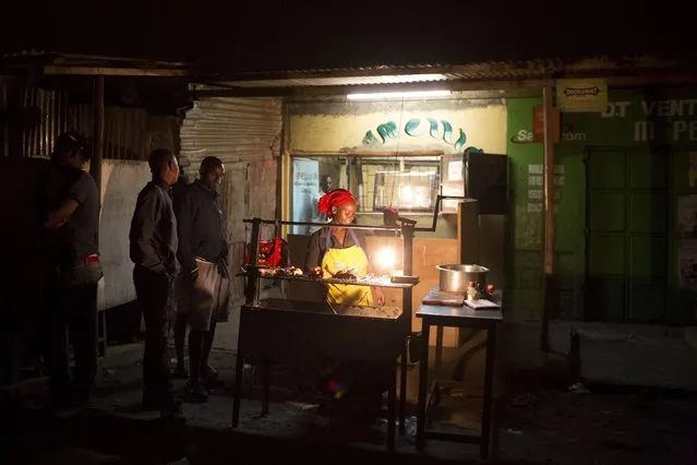 A woman grills chicken and meat in a roadside restaurant in Kariobangi, Nairobi, Kenya, June 13, 2015. (Photo by Siegfried Modola/Reuters)