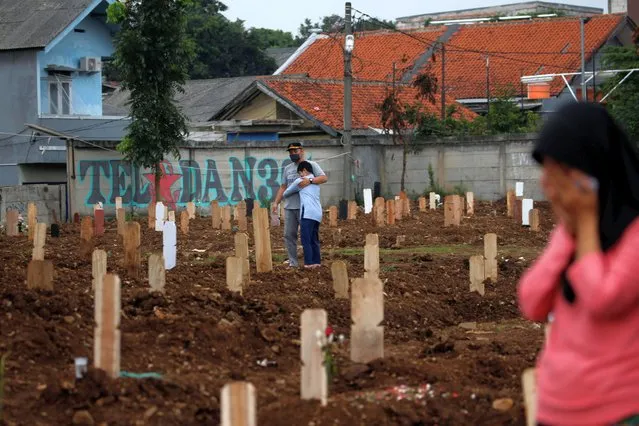 Mourners react at a burial area provided by the government for the victims of the coronavirus disease (COVID-19), at the Srengseng Sawah cemetery complex, in Jakarta, Indonesia, January 25, 2021. (Photo by Willy Kurniawan/Reuters)