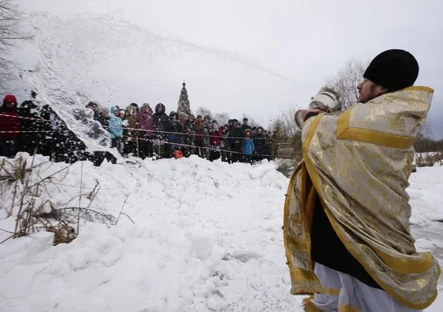 A priest conducts an Orthodox religious service during a water blessing ceremony on Epiphany Day in the village of Velikoye, Yaroslavl region, January 18, 2015. (Photo by Sergei Karpukhin/Reuters)
