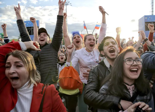 Fans celebrate after Russia scored the first goal during the opening match of the 2018 soccer World Cup, between Russia and Saudi Arabia, in the fan zone in Yekaterinburg, Russia, Thursday, June 14, 2018. (Photo by Vadim Ghirda/AP Photo)