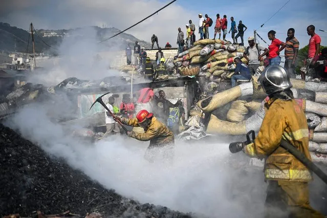 Haitian firefighters work to extinguish a fire in the market (Shada) in Petionville, Haiti, on May 4, 2023. (Photo by Richard Pierrin/AFP Photo)