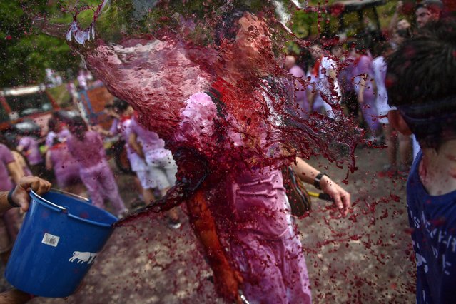 A man has wine thrown on his as he takes part in a wine battle, in the small village of Haro, northern Spain, Friday, June 29, 2018. (Photo by Alvaro Barrientos/AP Photo)