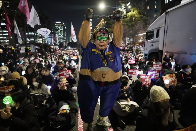 A participant wearing a mask of South Korean President Yoon Suk Yeol performs during a rally to demand his impeachment, outside the National Assembly in Seoul, South Korea, December 9, 2024. (Photo by Ahnn Young-joon/AP Photo)