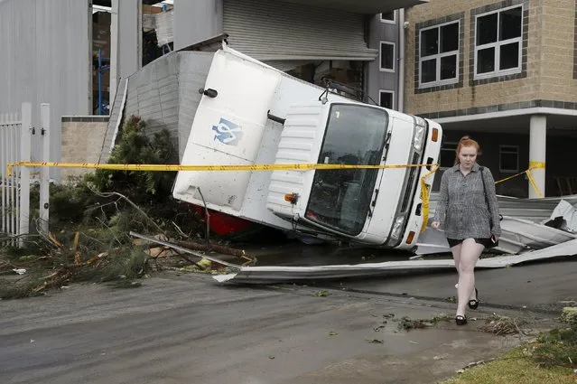 A truck lays overturned onto a car following strong winds at a Kurnell industrial park after a rare tornado hit the Sydney suburb December 16, 2015. (Photo by Jason Reed/Reuters)