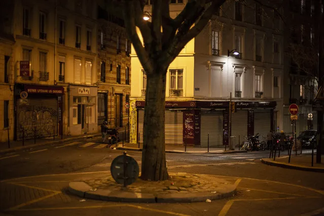 View of an empty street as the 6 p.m curfew starts in Paris, France, Friday, February 26, 2021. The curfew is to cover the whole country, including zones like Paris, where it previously hadn't started until 8 p.m. (Photo by Rafael Yaghobzadeh/AP Photo)