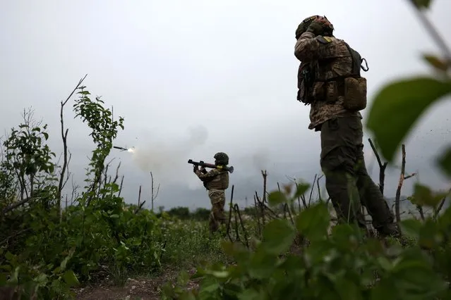 Ukrainian soldiers of the 28th Separate Mechanized Brigade fire a grenade launcher at the front line near the town of Bakhmut, Donetsk region, on June 17, 2023, amid the Russian invasion of Ukraine. (Photo by Anatolii Stepanov/AFP Photo)