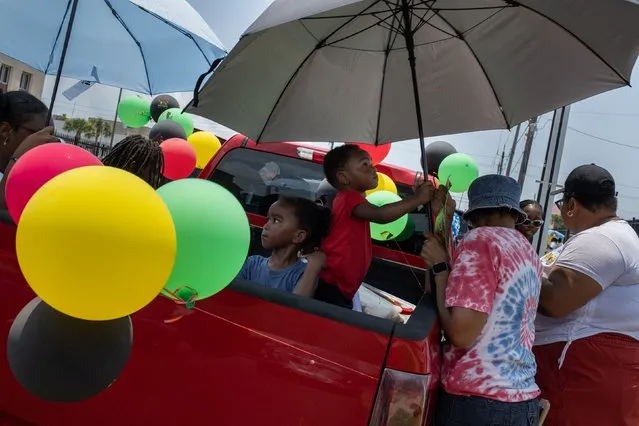 Artemis Mosley, 2, takes cover from hot weather under an umbrella during the Juneteenth Parade in Galveston, Texas, U.S., June 17, 2023. (Photo by Adrees Latif/Reuters)