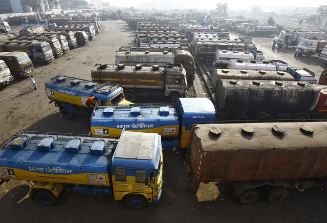Oil tankers are seen parked at a yard outside a fuel depot on the outskirts of Kolkata February 3, 2015. Falling oil prices have been a major windfall for India: Just weeks ago it faced failing to meet fiscal deficit targets, but can now expect a budget that not only hits its targets, but also provides extra cash to support reform. (Photo by Rupak De Chowdhuri/Reuters)