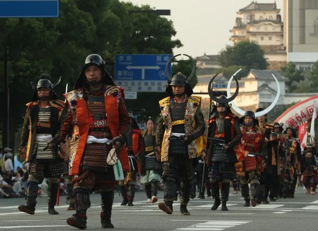 People dressed in Samurai costume and helmet march during the annual Himeji Castle Festival on August 3, 2013 in Himeji, Japan. The parade of Castle Queens is part of the traditional matsuri festival around the UNESCO world heritage Himeji Castle. (Photo by Buddhika Weerasinghe/Getty Images)