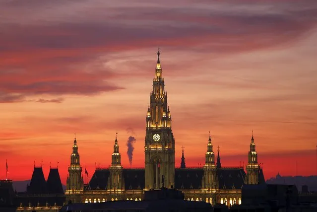 The setting sun illuminates the sky above the city hall in Vienna, Austria, December 27, 2015. (Photo by Heinz-Peter Bader/Reuters)