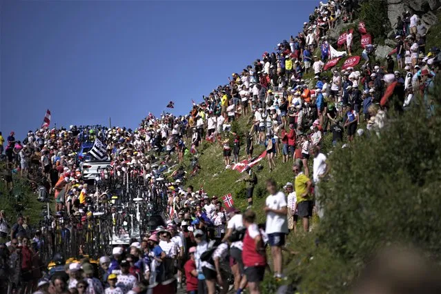 Team cars and motorcycles got stuck in the crowd on the Col de la Loze pass during the seventeenth stage of the Tour de France cycling race over 166 kilometers (103 miles) with start in Saint-Gervais Mont-Blanc and finish in Courchevel, France, Wednesday, July 19, 2023. (Photo by Daniel Cole/AP Photo)