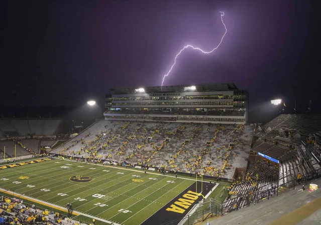 Football fans evacuate Kinnick Stadium as a bolt of lightning flashes overhead during a weather delay in the second half of an NCAA college football game between Nevada and Iowa Saturday, September 17, 2022, in Iowa City, Iowa. (Photo by Bryon Houlgrave/The Des Moines Register via AP Photo)