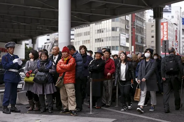 People line up to buy tickets for the Year-end Jumbo Lottery in a shopping district in Tokyo, November 26, 2015. (Photo by Thomas Peter/Reuters)
