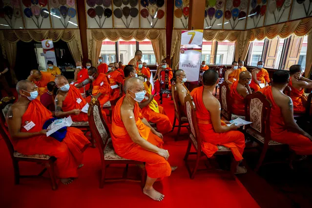 Thai Buddhist monks with plasters on their arms sit while being monitored for adverse reactions after receiving a shot of the vaccine against COVID-19 developed by AstraZeneca, during a vaccination drive following a new cluster, at a Buddhist temple in Bangkok, Thailand, 07 April 2021. Thai authorities ordered the closure of around 200 entertainment venues and enforced an emergency vaccine inoculation for 2,100 people related to venues linked to the new cluster. (Photo by Diego Azubel/EPA/EFE)