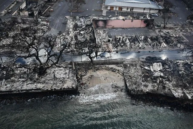 An aerial image taken on August 10, 2023 shows destroyed homes and buildings on the waterfront burned to the ground in Lahaina in the aftermath of wildfires in western Maui, Hawaii. At least 36 people have died after a fast-moving wildfire turned Lahaina to ashes, officials said August 9, 2023 as visitors asked to leave the island of Maui found themselves stranded at the airport. The fires began burning early August 8, scorching thousands of acres and putting homes, businesses and 35,000 lives at risk on Maui, the Hawaii Emergency Management Agency said in a statement. (Photo by Patrick T. Fallon/AFP Photo)