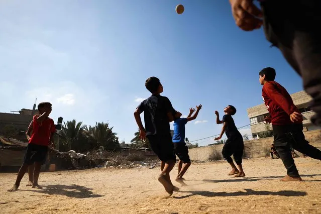 Palestinian youths play football outdoors in a poor neighbourhood in Gaza amid soaring temperatures and power cuts on July 31, 2023. (Photo by Mahmud Hams/AFP Photo)