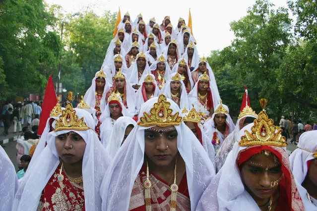 Indian brides sit during a procession before the mass marriages of 44 couples on the occasion of Akshaya Tritiya in Bhopal May 11, 2005. (Photo by Raj Patidar/Reuters)
