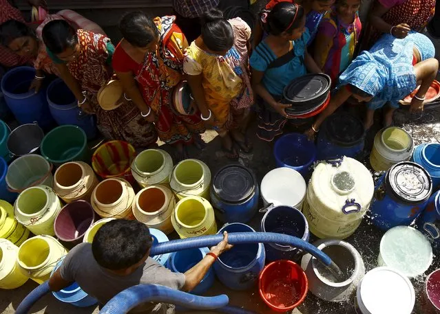 Residents get their containers filled with drinking water from a municipal water tanker at a slum in Kolkata March 22, 2015. (Photo by Rupak de Chowdhuri/Reuters)
