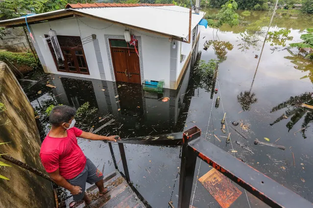 A Sri Lankan man stands near his flooded house after heavy rainfall in Kaduwela suburb of Colombo, Sri Lanka, 05 June 2021. (Photo by Chamila Karunarathne/EPA/EFE)