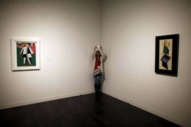 A woman takes pictures in between “Composition with white border” (L) and “Construction” by Russian-born artists Kasimir Malevich and Alexander Rodchenko during an international press tour of the Malaga branch of the State Museum of Russian Art of St Petersburg, a day before its inauguration in Malaga, southern Spain March 24, 2015. (Photo by Jon Nazca/Reuters)