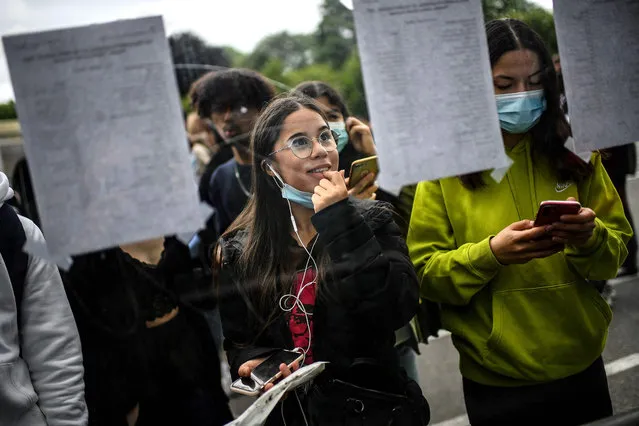 Students react as they check the results of the baccalaureat exam (high school graduation exam) at the Rodin high school in Paris on July 6, 2021. (Photo by Christophe Archambault/AFP Photo)