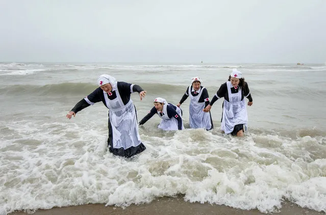 Costumed people get out of the North Sea during the Nieuwjaarsduik (New Year's Dive) on New Year's Day in Scheveningen, the Netherlands, 01 January 2017. (Photo by Bart Maat/EPA)