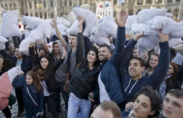 Youngsters hold pillows in the air for a photograph after taking part in a pillow fight downtown Bucharest, Romania, Saturday, April 4, 2015. (Photo by Vadim Ghirda/AP Photo)