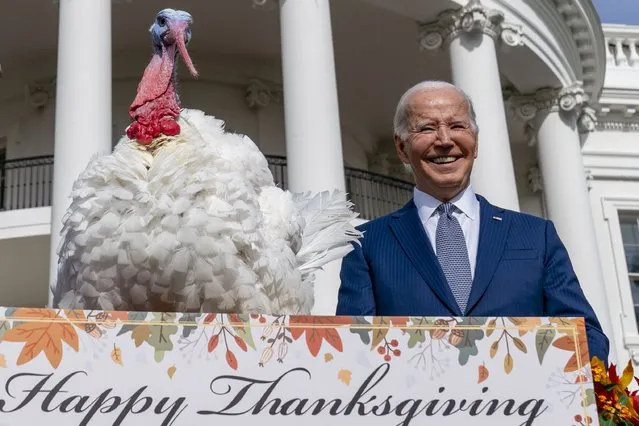 President Joe Biden stands next to Liberty, one of the two national Thanksgiving turkeys, after pardoning them during a ceremony on the South Lawn of the White House in Washington, Monday, November 20, 2023. (Photo by Andrew Harnik/AP Photo)