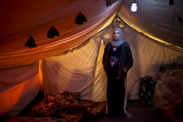 In this Monday, March 16, 2015 photo, Syrian refugee Wazeera Elaiwi, 29, a mother of two children now six months pregnant, poses for a portrait inside her tent at an informal settlement near the Syrian border, on the outskirts of Mafraq, Jordan. Pregnant refugee women living in informal tent settlements are among the most vulnerable of the hundreds of thousands of Syrians who have found shelter in Jordan. (Photo by Muhammed Muheisen/AP Photo)