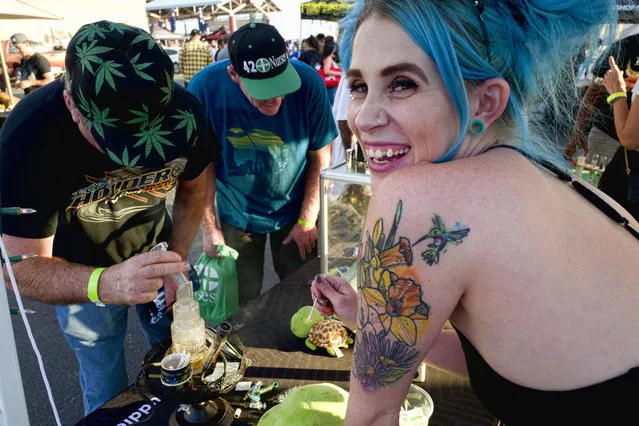 In this October 20, 2018, file photo, bud tender Kansas, right, offers up a puff of cannabis concentrates at the Turtle Puddles' booth at the cannabis-themed Kushstock Festival at Adelanto, Calif. California became America's largest legal marketplace in 2018, while Canada became the second and largest country with nationwide legal recreational marijuana. (Photo by Richard Vogel/AP Photo)