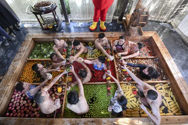 People born in the Year of the Pig drink beer in a hot pot shaped hot spring at a hotel to welcome the Chinese New Year on January 27, 2019 in Hangzhou, Zhejiang Province of China. The hot pot shaped hot spring in Hangzhou has vegetables and fruits, including lettuce, chilis, tomatoes, apples, bananas, mushrooms and corns. The Chinese New Year, the Year of the Pig, falls on February 5 this year. (Photo by VCG/VCG via Getty Images)