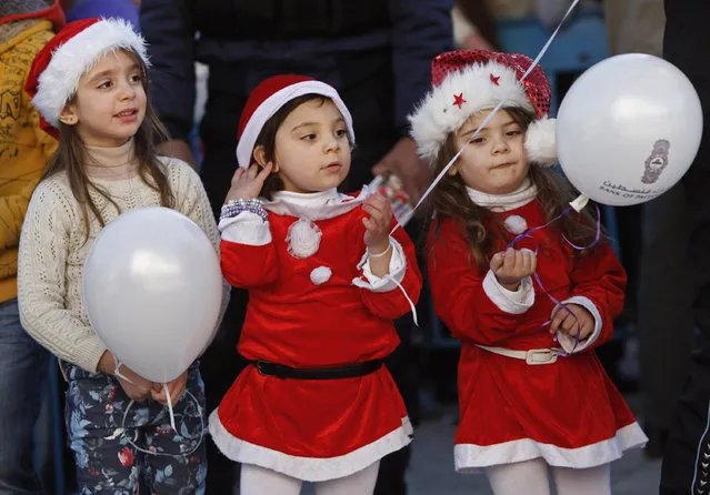 Palestinian children dressed up as Santa Claus pose for a photograph at Manger Square, outside the Church of the Nativity, traditionally believed by Christians to be the birthplace of Jesus Christ, in the West Bank town of Bethlehem, Tuesday, December 24, 2013. (Photo by Majdi Mohammed/AP Photo)