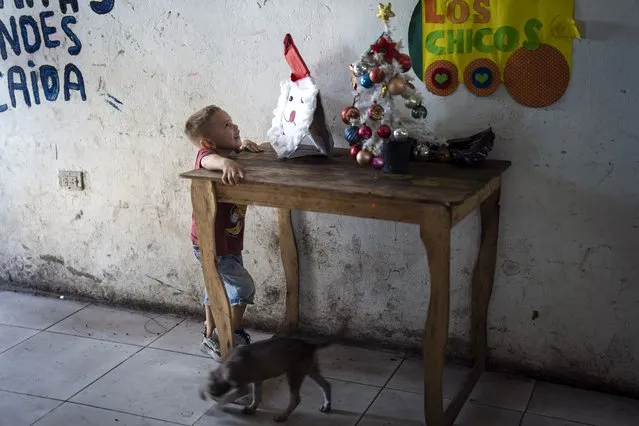 A child looks at a Santa craft at a pre-Christmas celebration organized by “Los Chicos de la Via” soup kitchen, in Buenos Aires, Argentina, Saturday, December 23, 2023. (Photo by Rodrigo Abd/AP Photo)