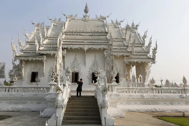 Tourist stroll at Wat Rong Khun also know as the White Temple designed by Thai visual artist Chalermchai Kositpipat in Chiang Rai Province, Thailand March 4, 2016. (Photo by Jorge Silva/Reuters)