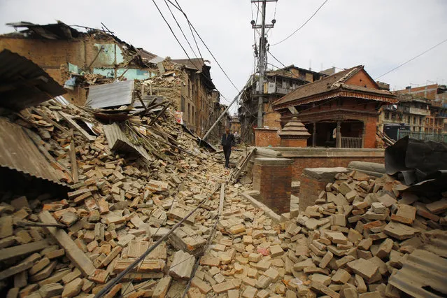 A Nepalese man walks through destruction caused by Saturday's earthquake, in Bhaktapur, Nepal, Sunday, April 26, 2015. (Photo by Niranjan Shrestha/AP Photo)